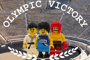 Three LEGO minifigure athletes stand in a stadium with the words 'Olympic Victory' above them.