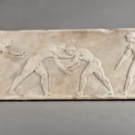 Image of a bas-relief showing four athletes in action.
