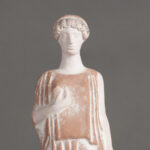 Image of a plaster cast head of woman wearing a peplos.