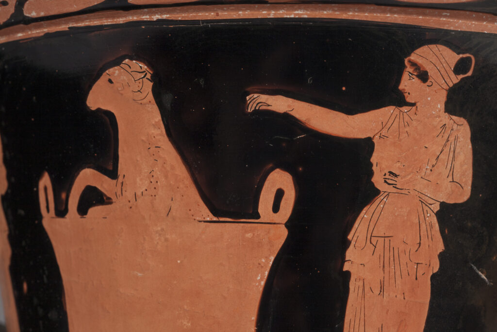 Close up view of Greek vase showing the witch Medea sprinkling magic herbs over an old ram in a pot.