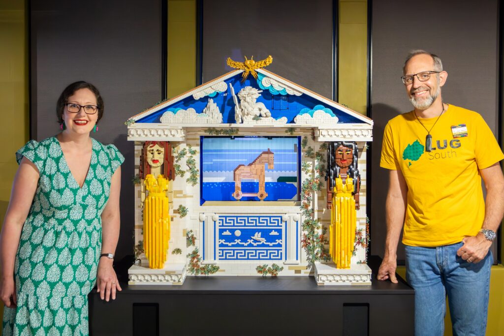 Emily and Jake standing either side of a large lego model of an ancient greek theatre. They are both smiling.