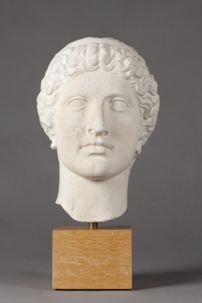 Plaster cast bust of a woman mounted on a wood block. This is a representation of the goddess Hera.