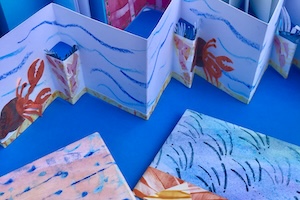Collection of blue paper craft booklets and papers.