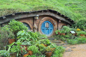 Landscape with door to a Hobbit house built into the side of a hill.
